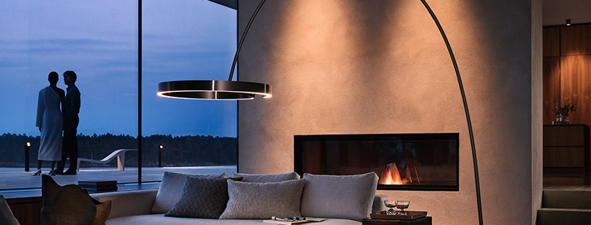 Couple standing by the window. Occhio floor light in the foreground.